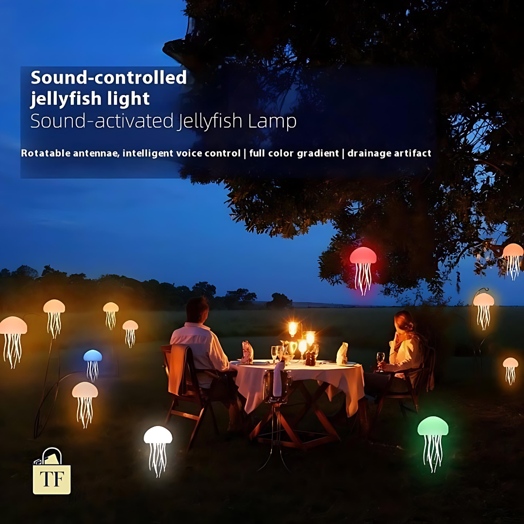 Two people sitting at a table under a sound-controlled jellyfish light in a dark outdoor setting.