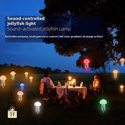 Two people sitting at a table under a sound-controlled jellyfish light in a dark outdoor setting.