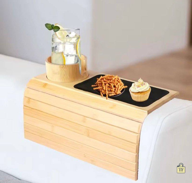 Wooden tray on a bed with a glass of water, snacks, and a cupcake.